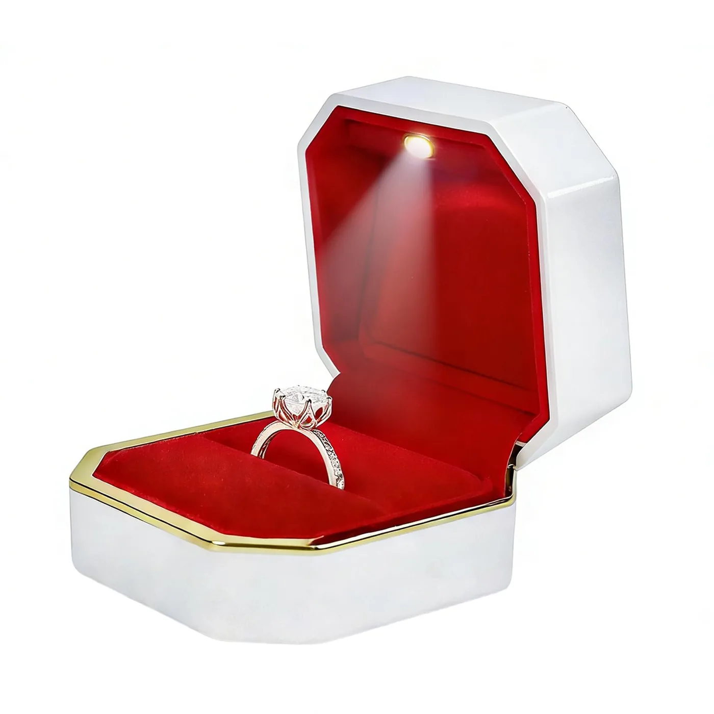 Ring box open on a white background with a ring inside the red lining