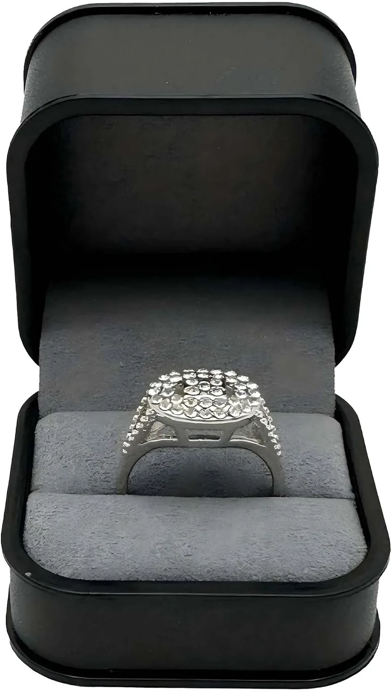 Black velvet ring box open with a grey suede interior and a diamond ring in the slot